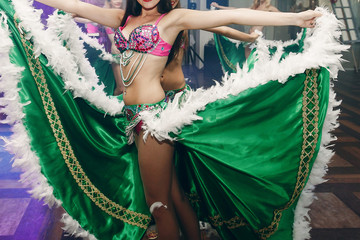 Sexy exotic belly dancers in traditional clothes with silk skirts performing at dance hall event in...