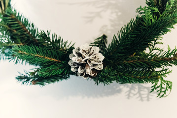 Fototapeta na wymiar christmas wreath with white pinecone. green fir branch. decorating christmas handmade nordich wreath. home preparation. rustic concept