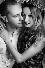 Fototapeta premium happy stylish couple hugging and sitting on background of luxury interior in studio, black white photo