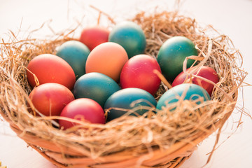 Obraz na płótnie Canvas easter colorful eggs in a basket spring concept on a white background with room for text