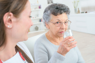 doctor giving medicine pills to an elderly woman