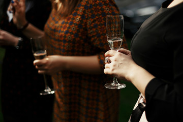 luxury stylish woman at elegant celebration holding champagne in restaurant terrace, rich feast outdoors