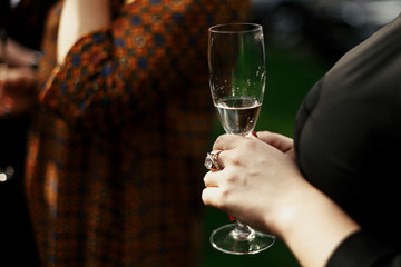 luxury stylish woman at elegant celebration holding champagne in restaurant terrace, rich feast outdoors