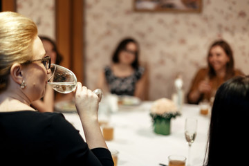 happy stylish woman holding glass of champagne and drinking at luxury restaurant