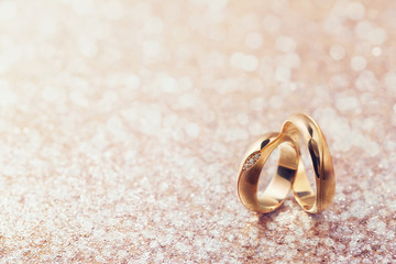 Two wedding rings on abstract background with copy space