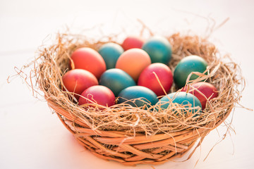 Fototapeta na wymiar easter colorful eggs in a basket spring concept on a white background with room for text