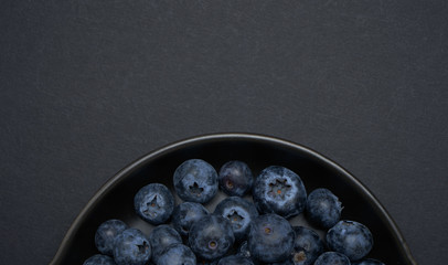 Closeup and crop Blueberries on a black clay pan with black background