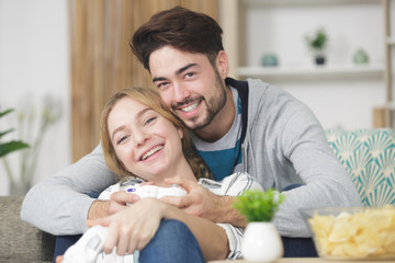 loving young couple hugging and relaxing on sofa at home
