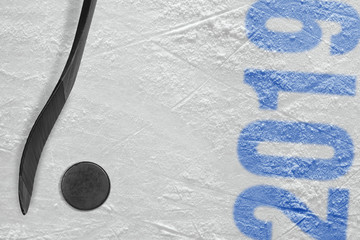 Puck and hockey stick on ice