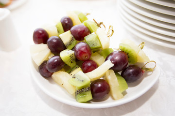 Buffet dishes.Canapes made from grapes of kiwi, apple