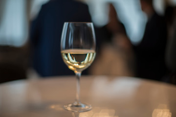 A glass filled with champagne on a table on a dark background