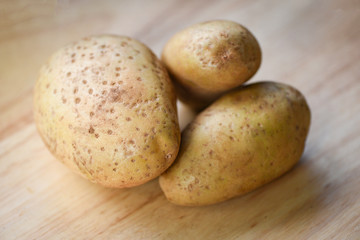 Fresh raw potato on wooden backgroun for