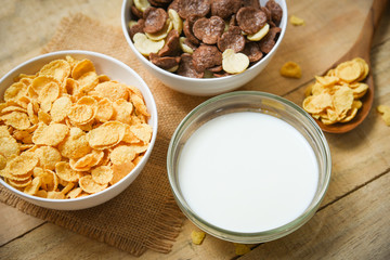 Breakfast Cornflakes and various cereals in bowl and milk cup on wooden background for cereal healthy food