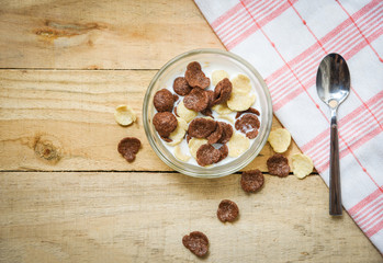 Breakfast cereals in bowl and spoon with milk on wooden background for cereal healthy food