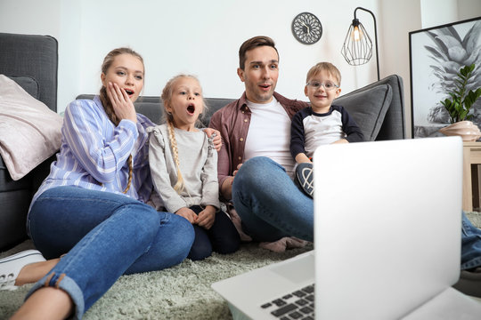 Emotional family watching cartoons at home