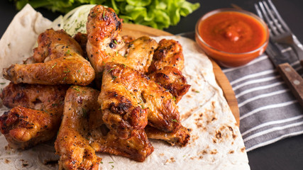 Tasty grilled chicken wings with red sauce.