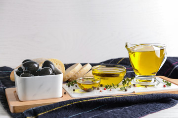 Tasty olive oil with fresh bread on table