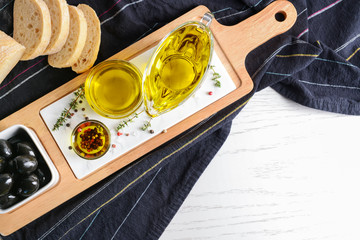 Tasty olive oil with fresh bread on white table