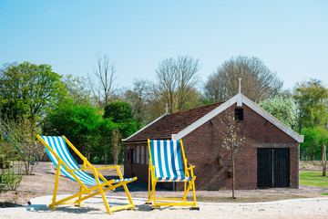 Fototapeta na wymiar giant sun chairs on sand in Renesse. The Netherlands