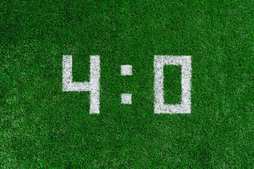 Football score.White numbers four and zero are drawn on the green grass,creative scoreboard