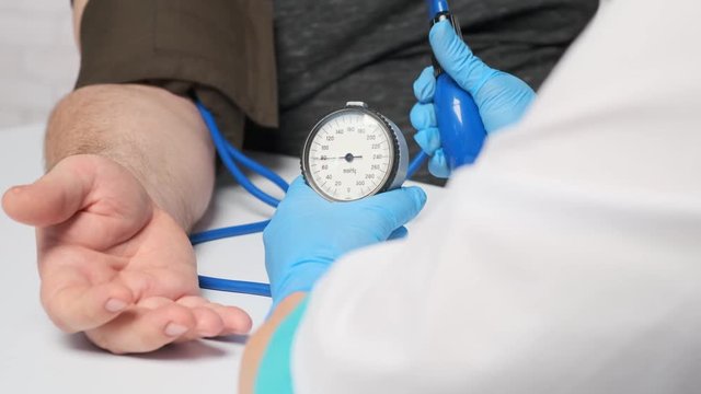 doctor measures the pressure of the patient using a mechanical tonometer.