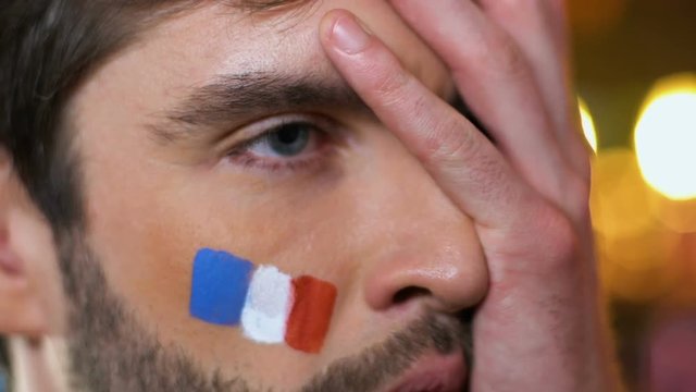 French male fan making face palm gesture, upset about favorite team losing game