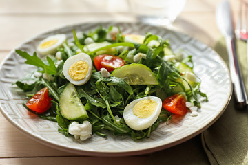 Tasty arugula salad on plate
