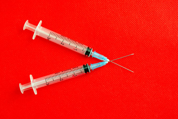 medical syringes on a red background