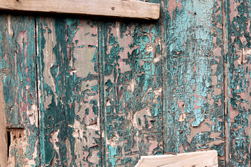 Background texture of the old board with peeling green paint. Horizontal, close-up, nobody. Concept of wear and restoration.