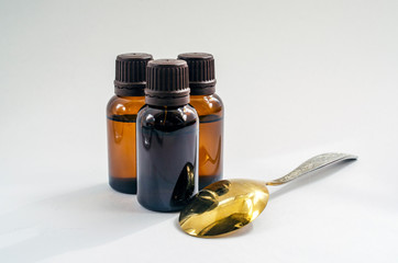 brown bottle of liquid and a spoon