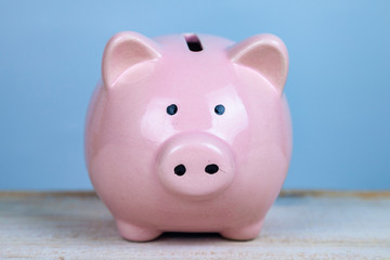 Pink pig money box on a wooden background