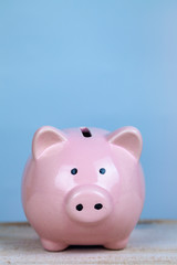 Pink pig money box on a wooden background