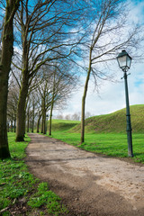 Fototapeta na wymiar walking path with trees and lanterns in fortified city Geertruidenberg, The Netherlands