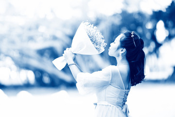 Asian bride woman portrait smiling and hold flower bouquet beautiful in the outdoor garden park