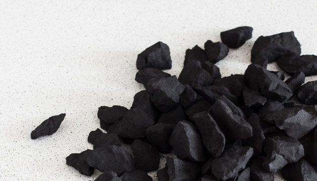 black shungite stones lie on a white background,with a copy of the space