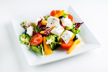greek salad with feta on the white plate