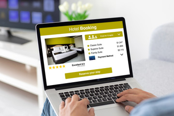 male hands on keyboard laptop with app hotel booking