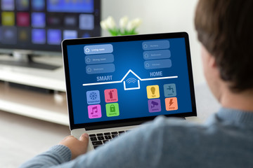 man holding laptop with app smart home on the screen