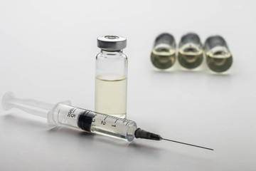 Subcutaneous syringe. Syringes with blue needles. Medical Injectors. Medical glass injection bottle. Ampoules with injections.