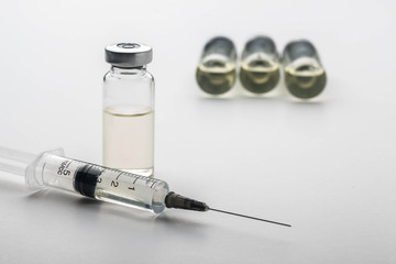 Subcutaneous syringe. Syringes with blue needles. Medical Injectors. Medical glass injection bottle. Ampoules with injections.