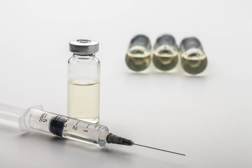 Subcutaneous syringe. Syringes with blue needles. Medical Injectors. Medical glass injection bottle. Ampoules with injections.