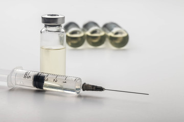 Subcutaneous syringe. Syringes with blue needles. Medical Injectors. Medical glass injection bottle. Ampoules with injections.