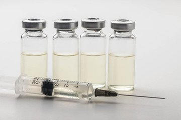 Subcutaneous syringe. Syringes with blue needles. Medical Injectors. Medical glass injection bottle. Ampoules with injections.