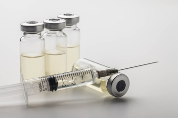 Subcutaneous syringe. Syringes with blue needles. Medical Injectors. Medical glass injection bottle. Ampoules with injections.