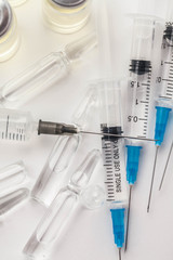 Subcutaneous syringe. Syringes with blue needles. Medical Injectors. Medical glass injection bottle. Ampoules with injections.