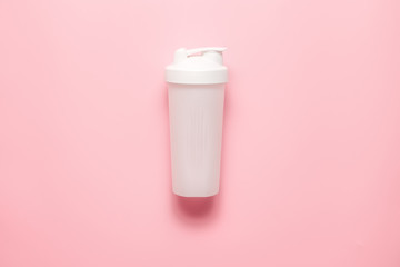 White plastic sports shaker on pastel pink  background.  Trendy athletics and sport minimal  concept. Female fitness.Flat lay, top view.  - obrazy, fototapety, plakaty