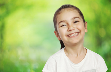 Happy cute child girl on the blur green background