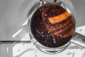 Barista preparing hot tasty drink from copper turk, boils water for coffee on small fire in cezve. Coffee turk made of organic copper, cezve to kitchen. Copper turk for real gourmet coffee at cezve