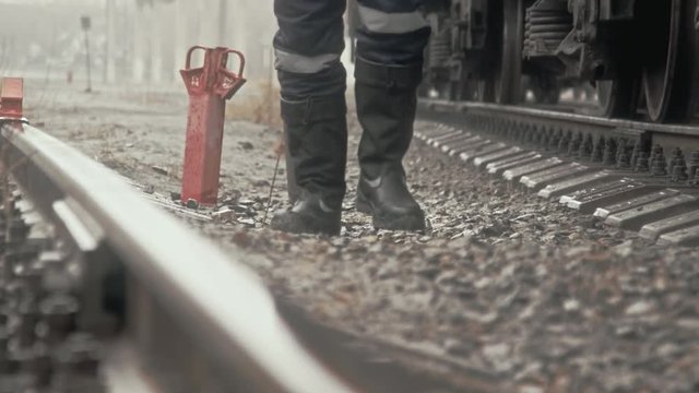 Worker is walking along the railway tracks