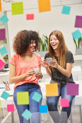 Junge Business Frau im Büro freut sich über SMS